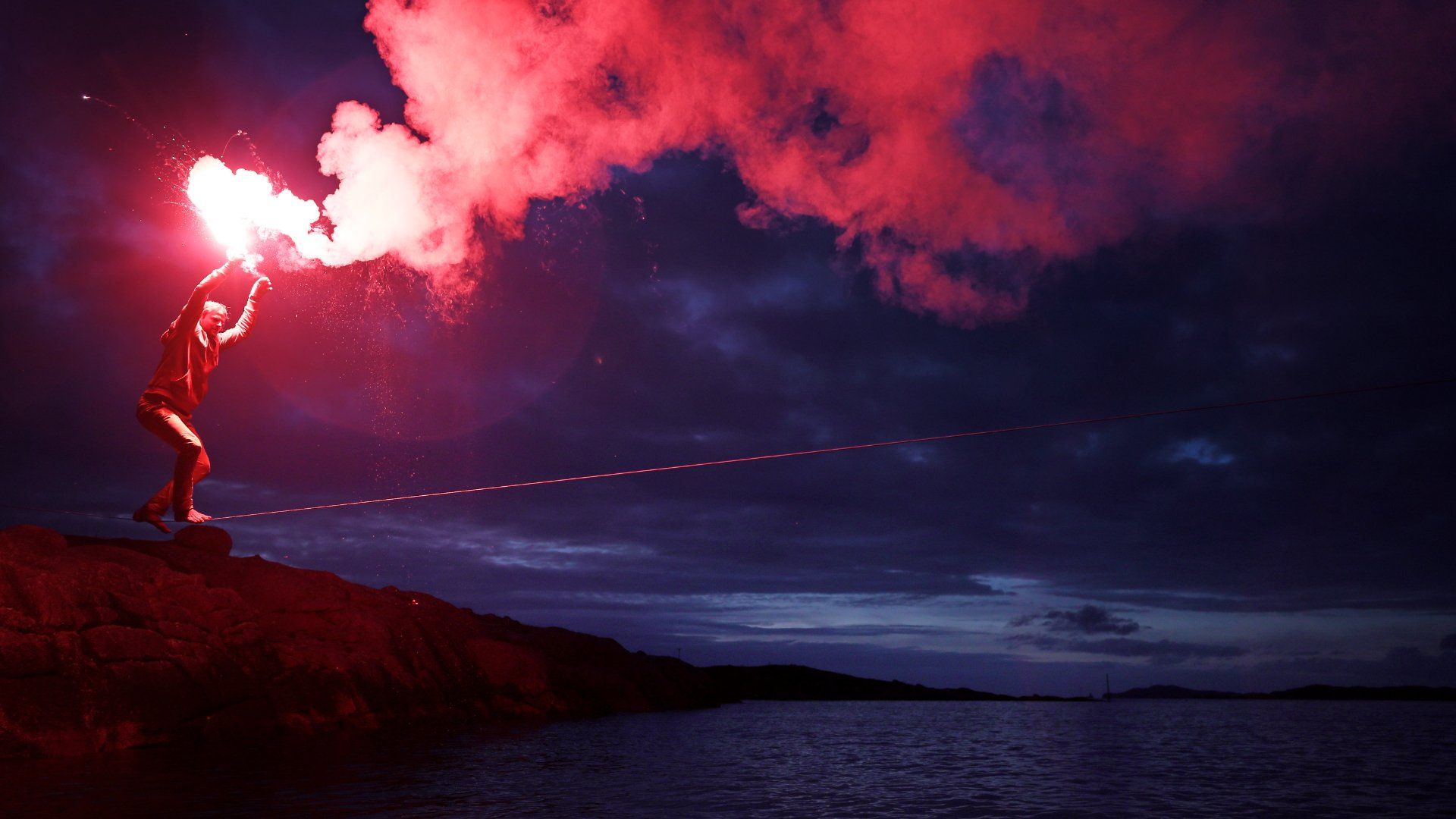 Slackliner with fire on rocks shot on the Canon EOS R and RF 28-70mm F2L USM